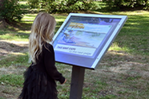 young girl looking at interpretive sign
