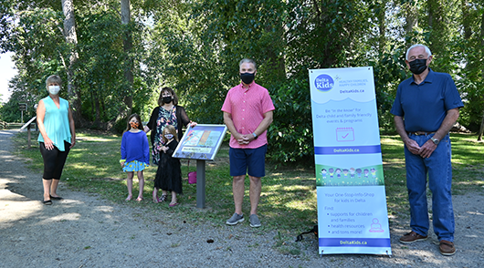 small crowd standing near sign in park