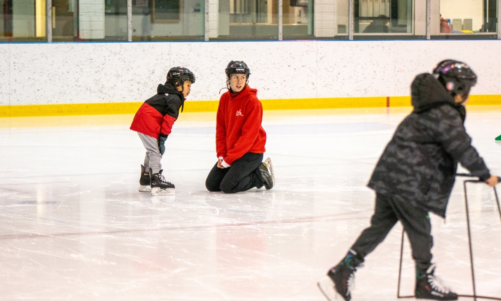The instructor helps a new skater with some basics.