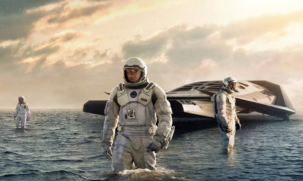 A group of astronauts, led by Matthew MConnoghy walk through a watery planet. 