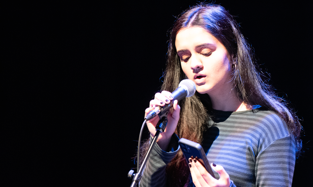 A poet performs a piece at an open mic spoken word night.