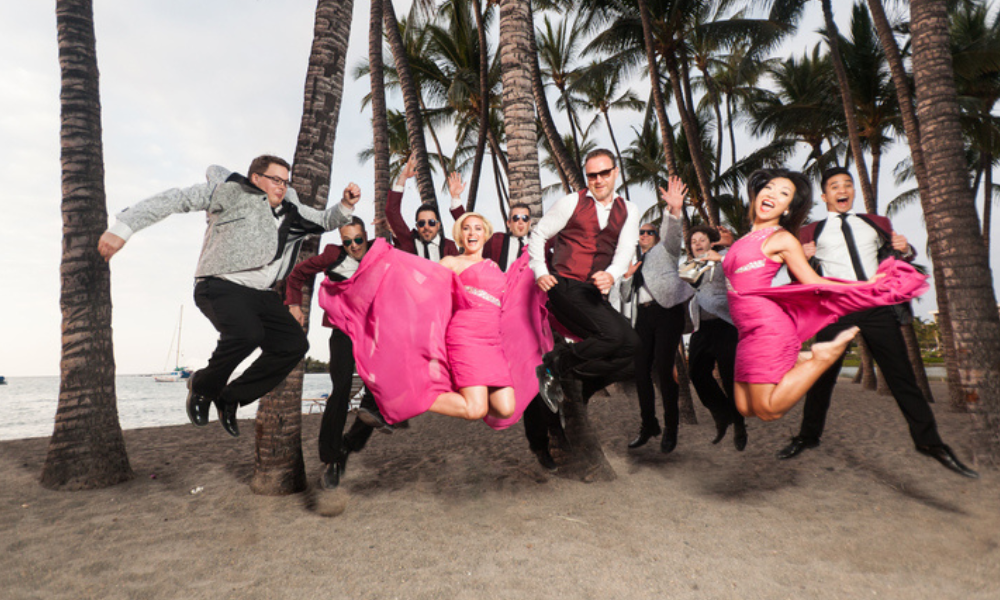 10 person band jumping in air posing