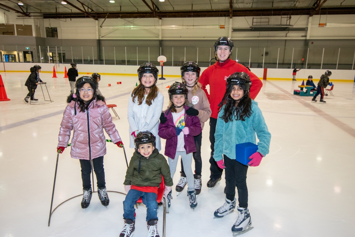 A class of skating students stand together