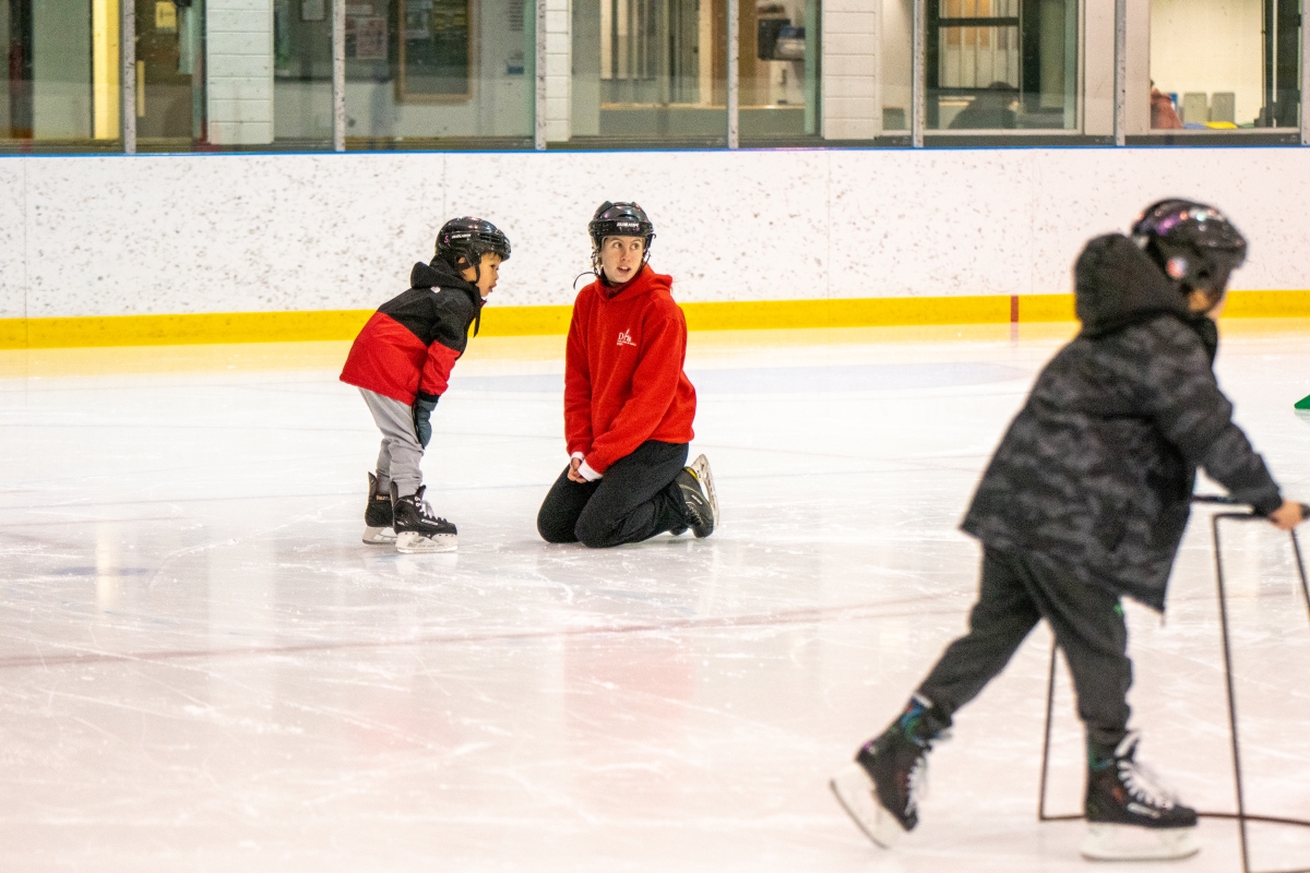 The instructor helps a new skater with some basics.