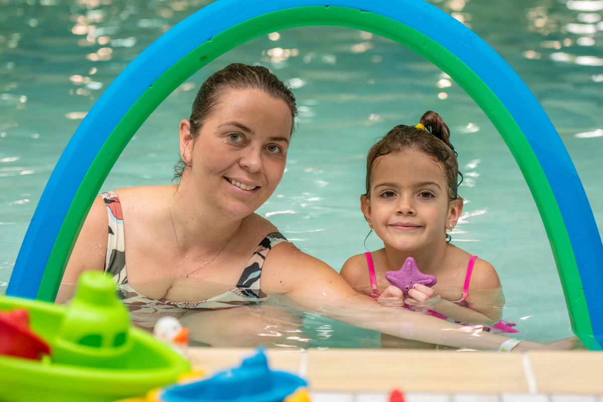 A mom and daughter enjoy swimming in the winskill teach pool.