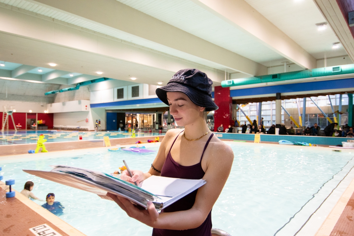A swim teacher at Sungod Recreation Centre takes attendance.