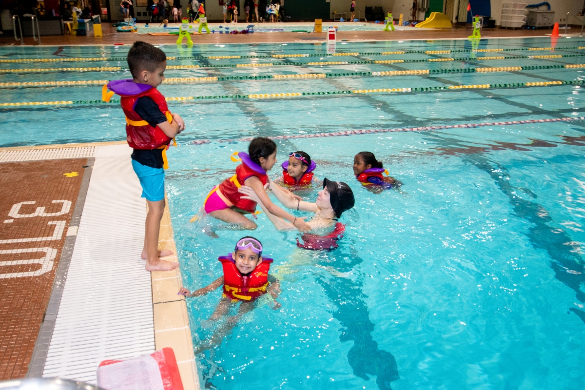 A student stands in a lifejacket on the corner of the Sungod dive tank.