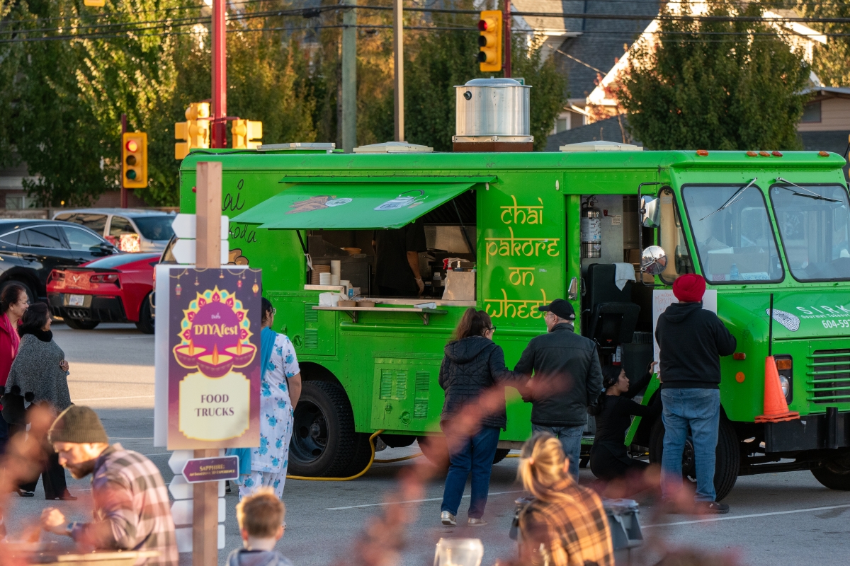 green food truck with people lined up outside