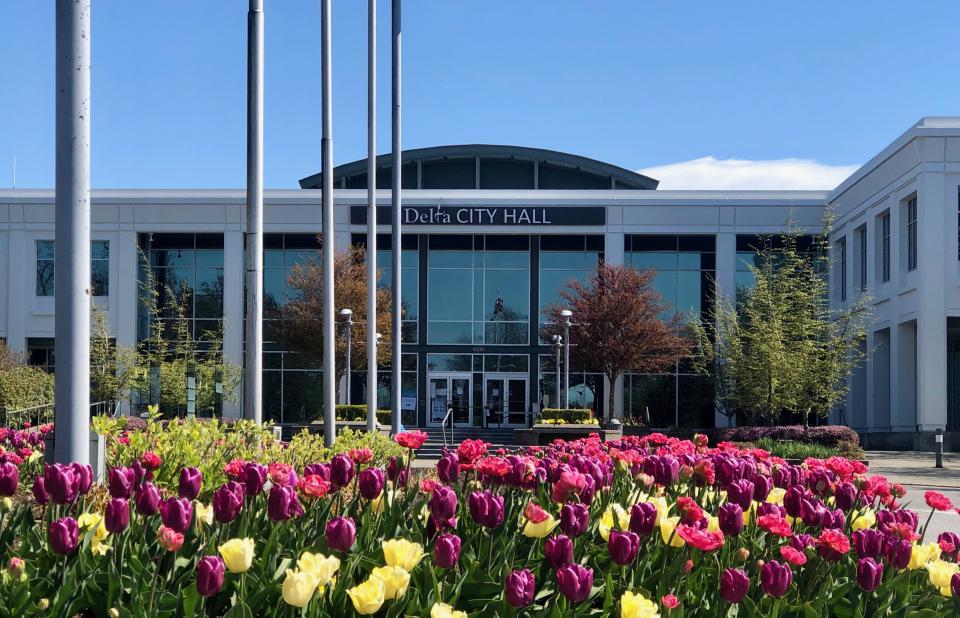 Delta city hall with flowers in bloom in front of the building