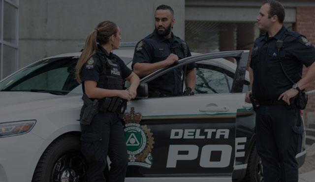 Police officers in front of delta police car