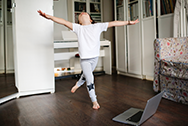 Kid jumping with arms outstretched in a living room