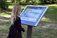 young girl looking at interpretive sign