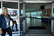 woman holding a glass door open