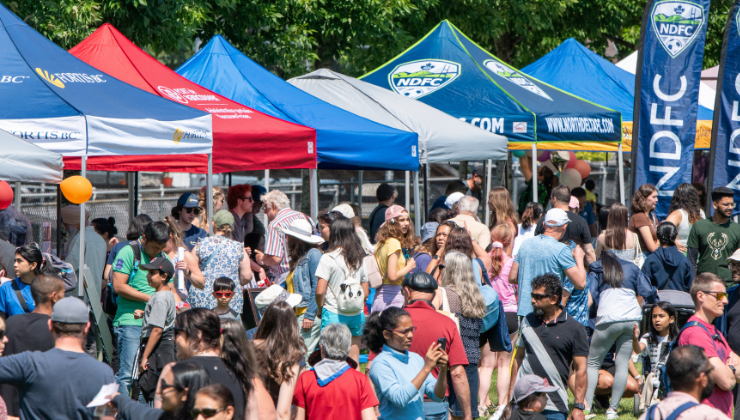 A crowd gathers at booths around the North Delta Market. 