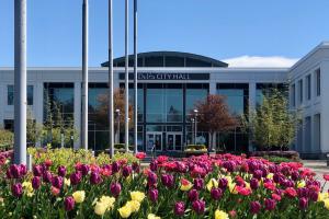 Delta city hall with flowers in bloom in front of the building