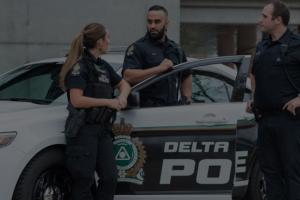 Police officers in front of delta police car