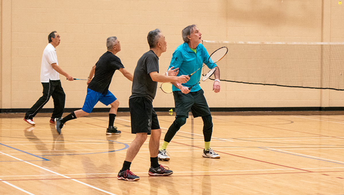a group of people play badminton, a drop-in activity that will be lightly affected by the incoming 2026 Fees & Charges Bylaw update